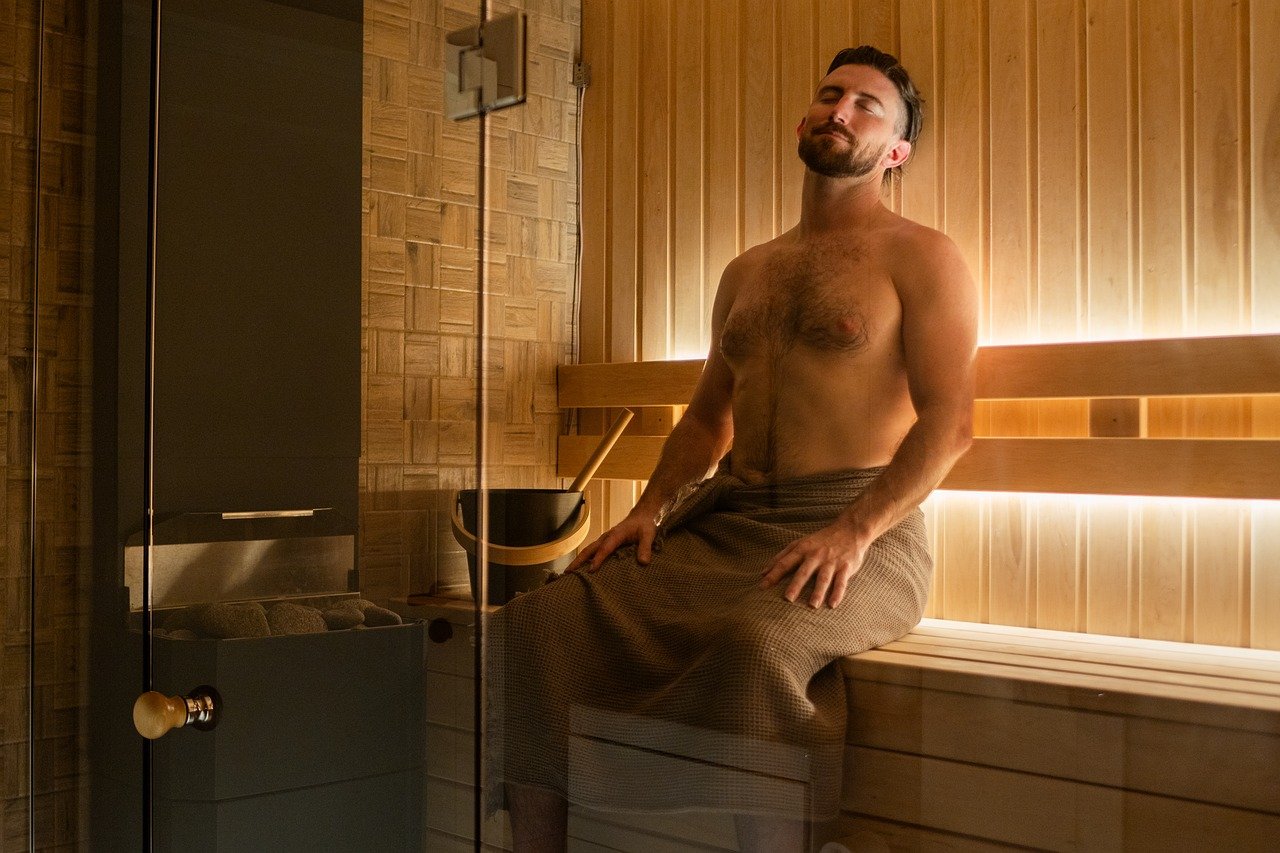 Mann, der mit geschlossenen Augen in einer Sauna entspannt.